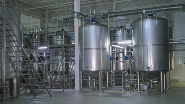 Shiny Stainless Steel Storages, Valves and Pipes in a Modern Dairy. alt