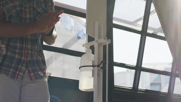 Mixed race male cafe worker disinfecting hands alt