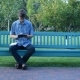 Man on Bench in Park Using a Tablet and Writing in Notepad - VideoHive Item for Sale