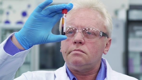 Man Lifts the Test-tube Up at the Laboratory alt