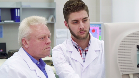 Man Points His Hand on Monitor at the Laboratory alt