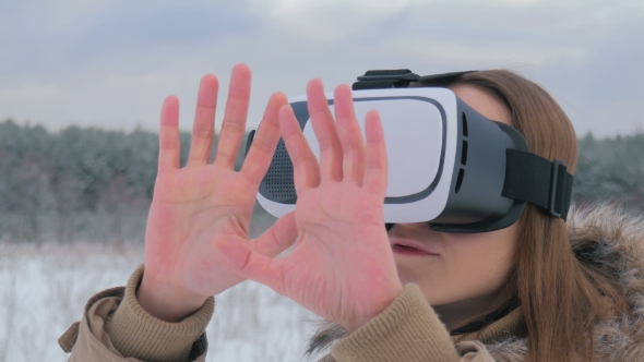 Woman Uses a Virtual Reality Glasses in Winter Forest