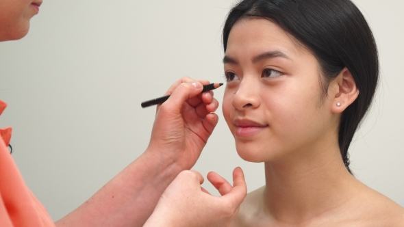 Beauty Specialist Uses Cosmetic Pencil alt