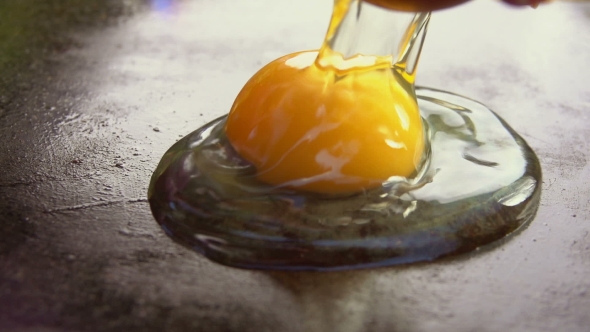 Raw Egg Is Broken Into a Grill