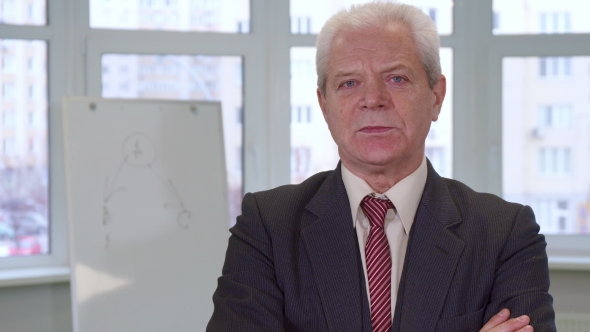 Senior Businessman Crosses His Arms on His Chest alt