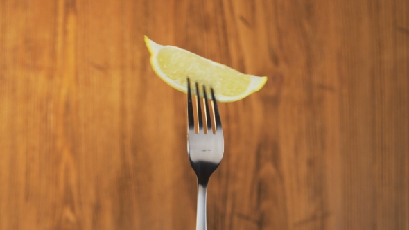 Fork With Lemon on Wooden Background alt
