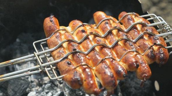 Cooking of Grilled Sausages on Coals on the Grill