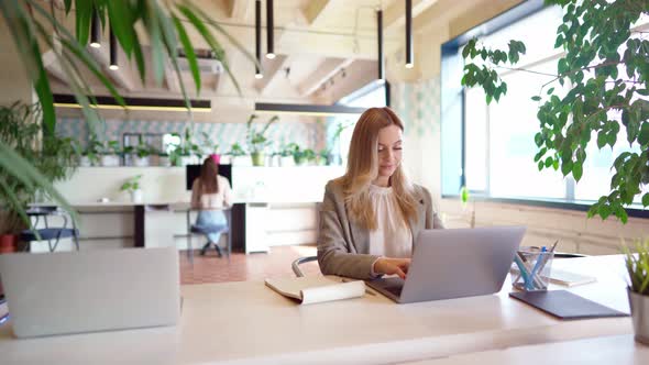 Young Businesswoman in Formal Suit Working at the Table in Modern Open Space Office alt