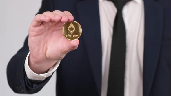 Businessman Holding in Hand Ethereum Coin. Cryptocurrency Concept