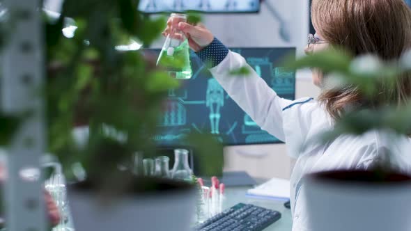 Biotechnology Researcher Looks at Green Tubes alt