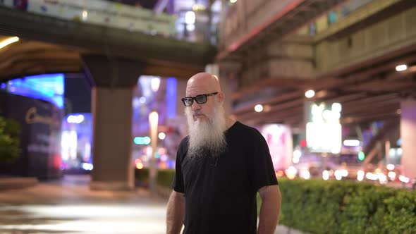 Mature Bald Bearded Tourist Man Exploring the City Streets at Night