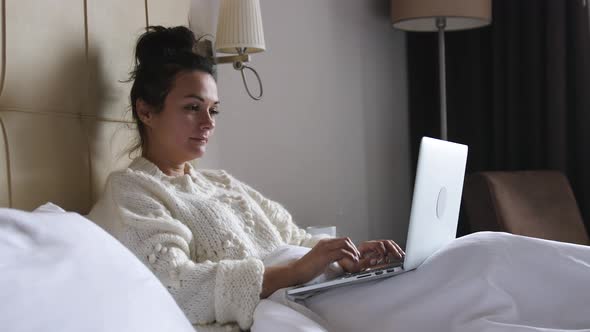 Woman Work on Laptop Computer and Sit on Bed