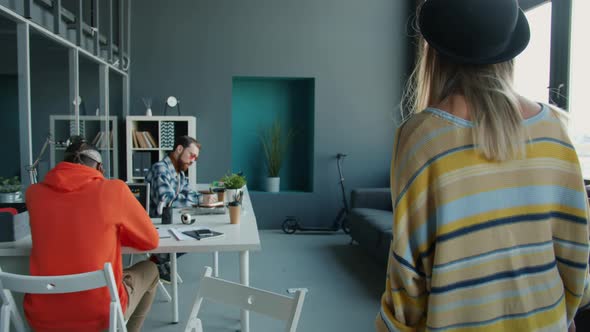 Dolly Shot of Businesswoman Walking in Office Watching People Playing Table Football and Working alt