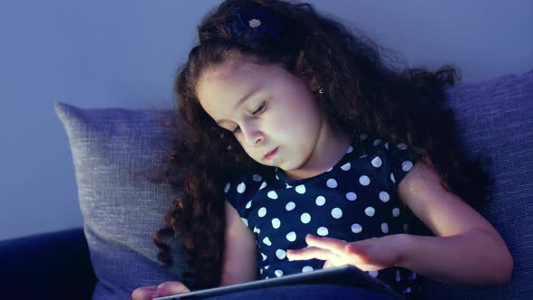 Cute Child Entertaining With Tablet. Little Girl Spending Leisure Time Playing Mobile Game alt