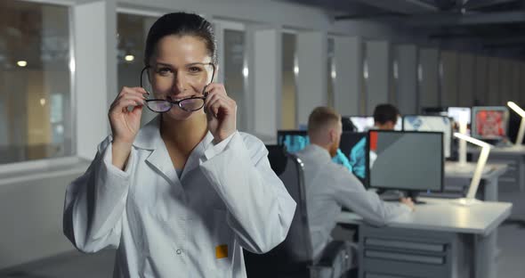 Female Cheerful Engineer in Lab Coat and Glasses in Office alt