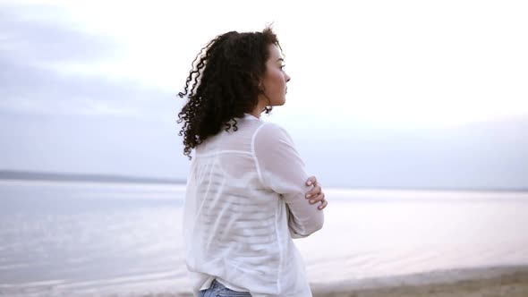 Close Up Side Footage of an Attractive Young Woman Walking By Seaside in Water Wearing a White Shirt alt