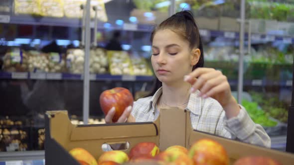 Woman Buying Apples in Supermarket