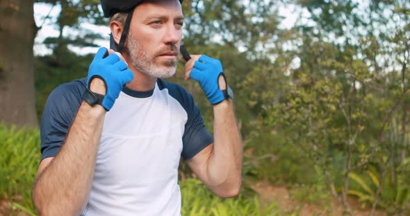 Male cyclist wearing helmet at countryside alt
