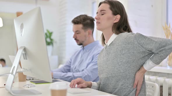 Tired Creative Woman Having Back Pain in Modern Office alt