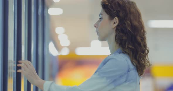 Girl Comes to the Cold Store and Takes Out the Frozen Vegetables in the Supermarket alt