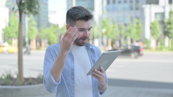 Young Man Celebrating Online Win on Tablet Outdoor alt