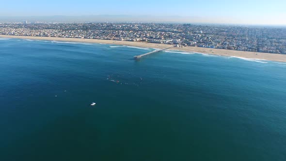 Aerial shot of surfers paddling out on the ocean. alt