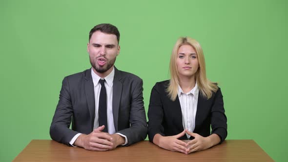Young Businessman Making Funny Faces to Young Businesswoman