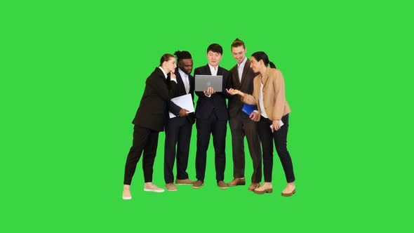 Group of Colleagues Discuss Project on Laptop on a Green Screen Chroma Key