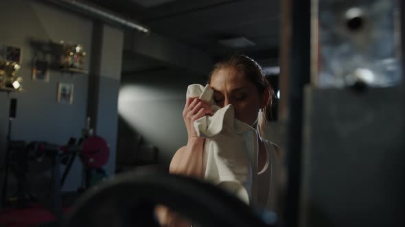 Closeup of the Face of a Young Woman Who Wipes Her Face with a Towel in the Gym alt