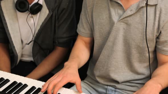 Two students playing on keyboard alt