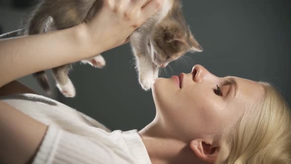 Close Up of the Charming Young Woman Caressing a Small Grey Cute Pussycat and Kissing It