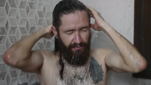 Young Bearded Man is Washing Head in a Shower at Home Closeup