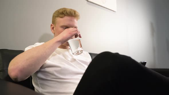 White Red head man drinking a glass of water - Still shot alt
