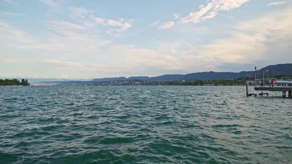 Pan Shot of Zurich Lake and Pier with People in Summer Day