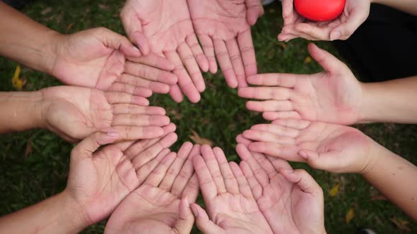 Hand give a red heart to many hands of people alt