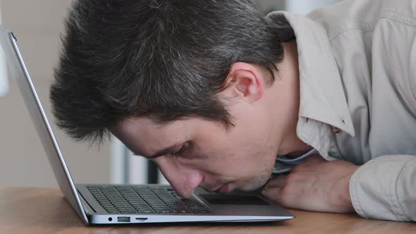 Portrait of Caucasian Man Millennial Lazy Worker Sleeping Lies on Laptop in Office at Table at alt
