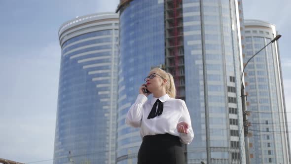 woman talking on the phone on the background of skyscrapers