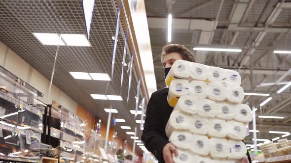 Man Walking in Medical Mask with Toilet Paper Shopping Bags During the Quarantine Coronavirus alt