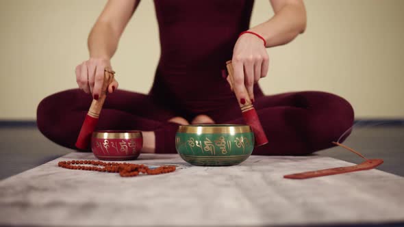 Unrecognizable Female Hands Clattering on Some Traditional Buddhism Pots alt