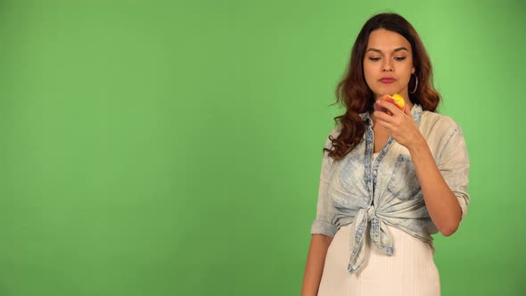 A Young Beautiful Caucasian Woman Eats an Apple  Green Screen Background