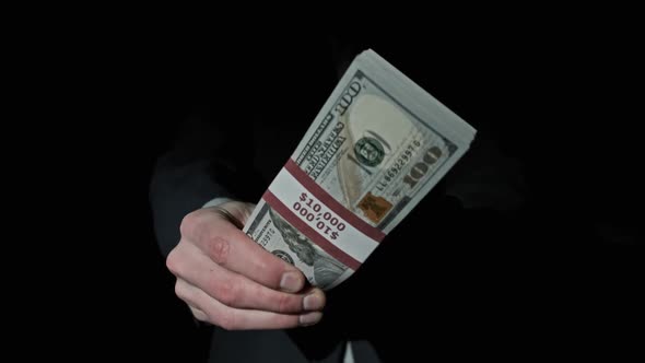 Stack of 10000 American Dollars in Bundle in Male Hands on Black Background alt