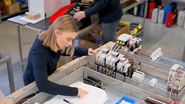 Woman checking cables at batteries