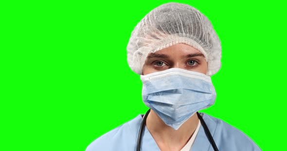 Front view of female doctor looking at camera with green screen alt
