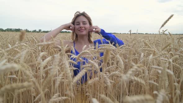Beautiful Ukrainian Woman Wearing Dress in Ukrainian National Flag Colours Blue and Yellow at Wheat alt
