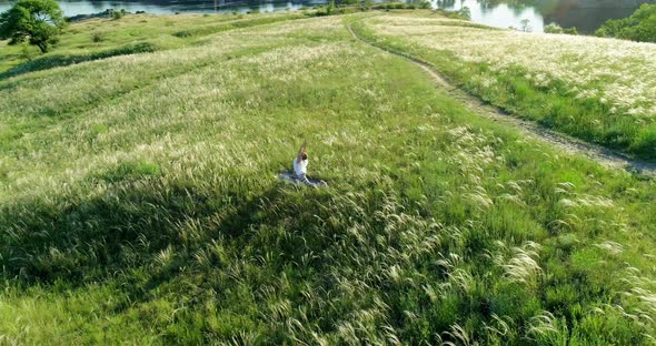Girl meditates on a beautiful green meadow alt