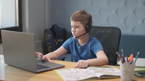 Portrait of boy learning online at home. Closeup child using laptop computer sitting at table alt