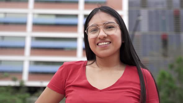 Portrait of Carefree Hispanic Latin American Young Woman Smiling in the City alt