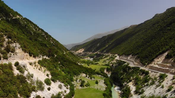 Aerial Drone Footage View Flight Over Mountain with Forests Fields and River in Sunrise Soft Light