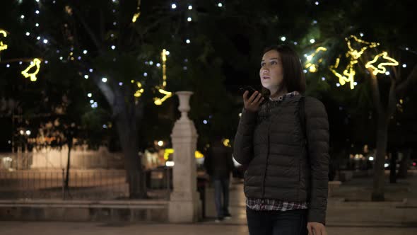 Girl Using Smart Phone Voice Recognition Dictates Thoughts Voice Dialing Message at Night Evening alt