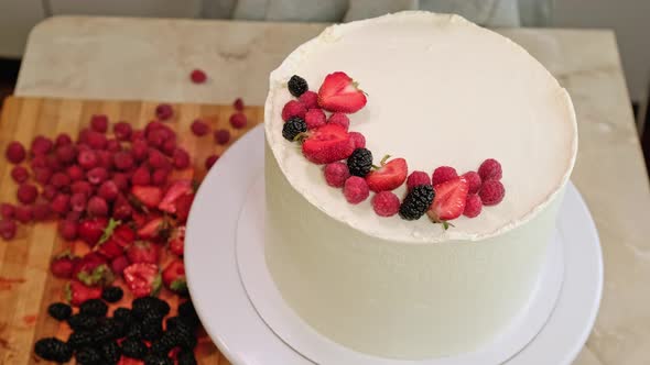Pastry Chef Woman Decorate Cake Fresh Berries on Rotating Table at Home
